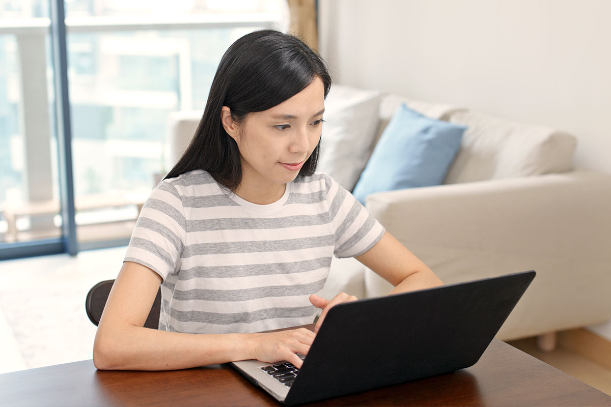 Student taking proctored/invigilated exam online at home on laptop